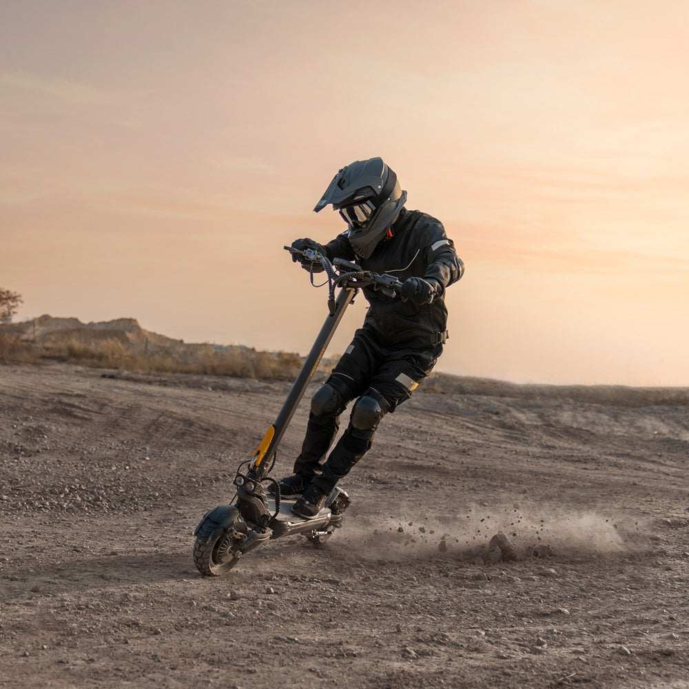 Person riding Ausom F1 Max Trottinette électrique off-road with protective gear at sunset